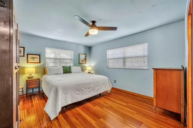 a bedroom with a bed and wooden floor