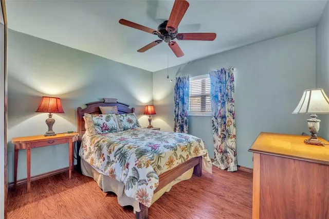 a bedroom with a bed and a dresser with wooden floor