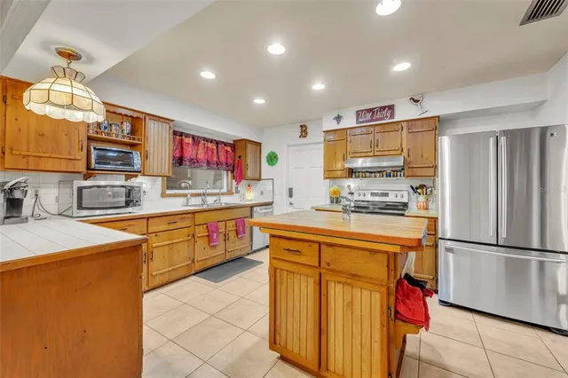 a kitchen with stainless steel appliances granite countertop a refrigerator and a stove top oven