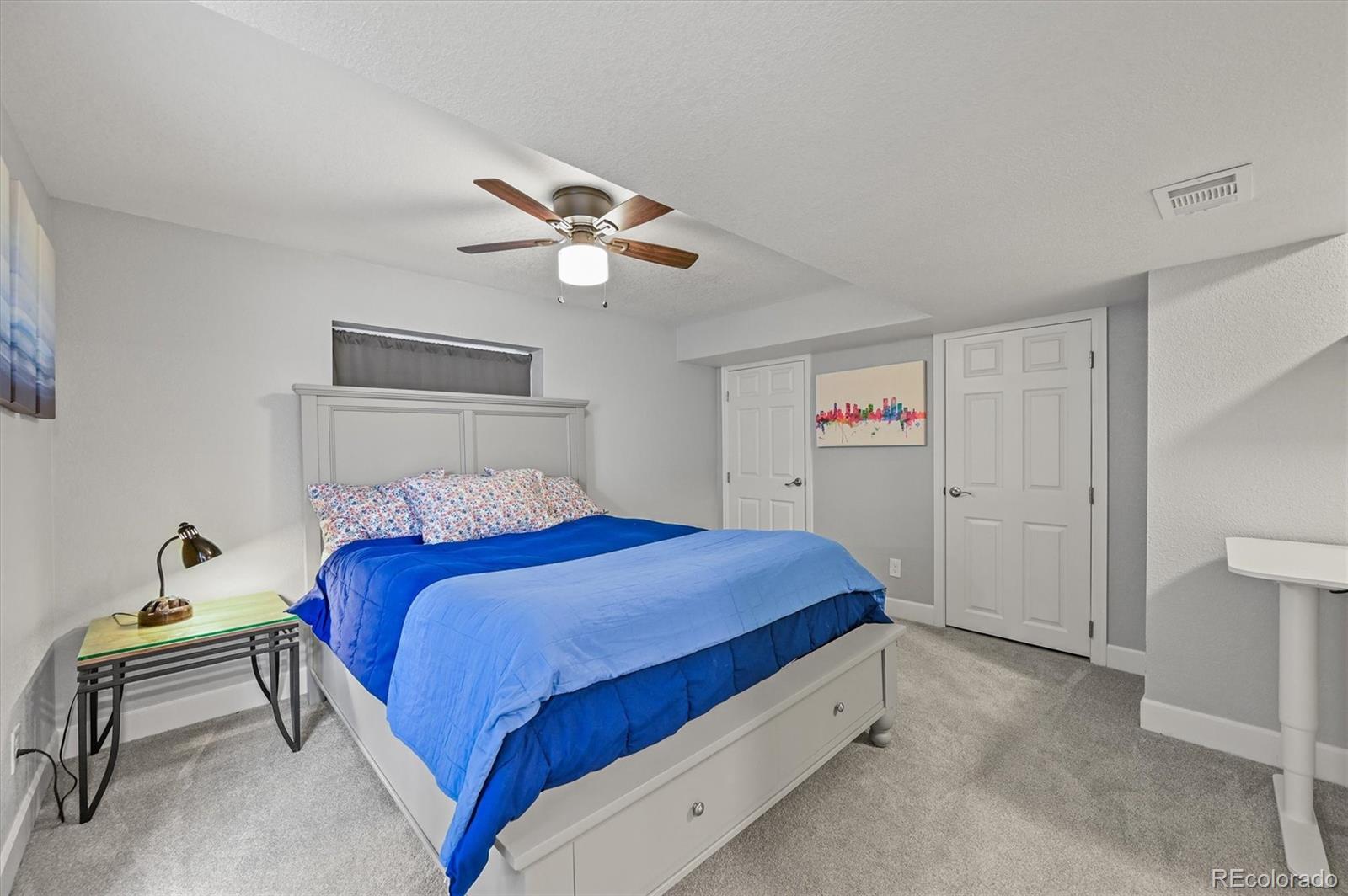2249 Weatherstone Circle Highlands Ranch, CO 80126 - Photo 38 of 46 a bedroom with a bed and a chandelier