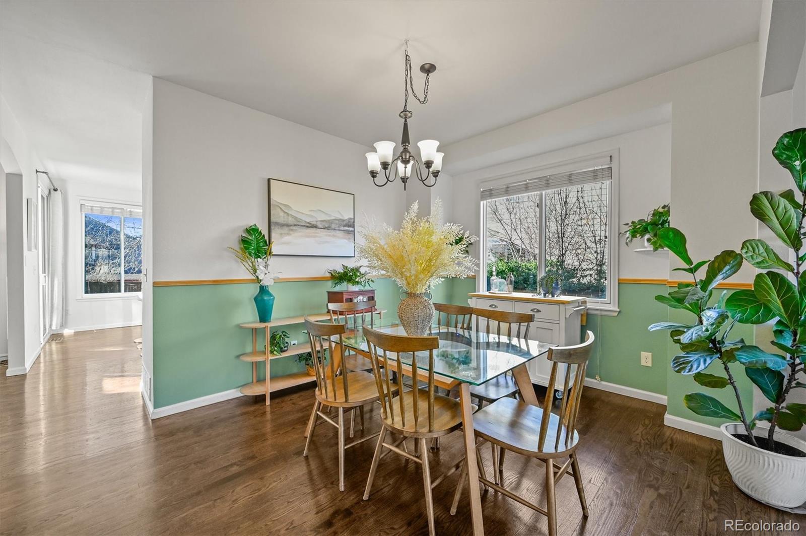 2249 Weatherstone Circle Highlands Ranch, CO 80126 - Photo 8 of 46 a view of a dining room with furniture a chandelier and wooden floor