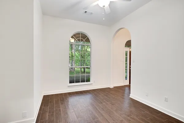 an empty room with a ceiling fan and a window