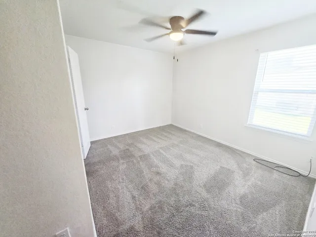 an empty room with fan and entrance
