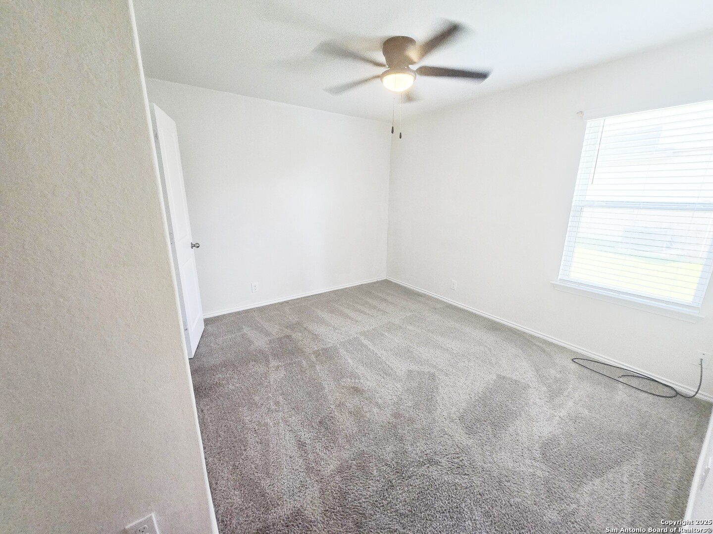 437 Middle Grn Loop Floresville, TX 78114 - Photo 16 of 25 an empty room with a window and a fan