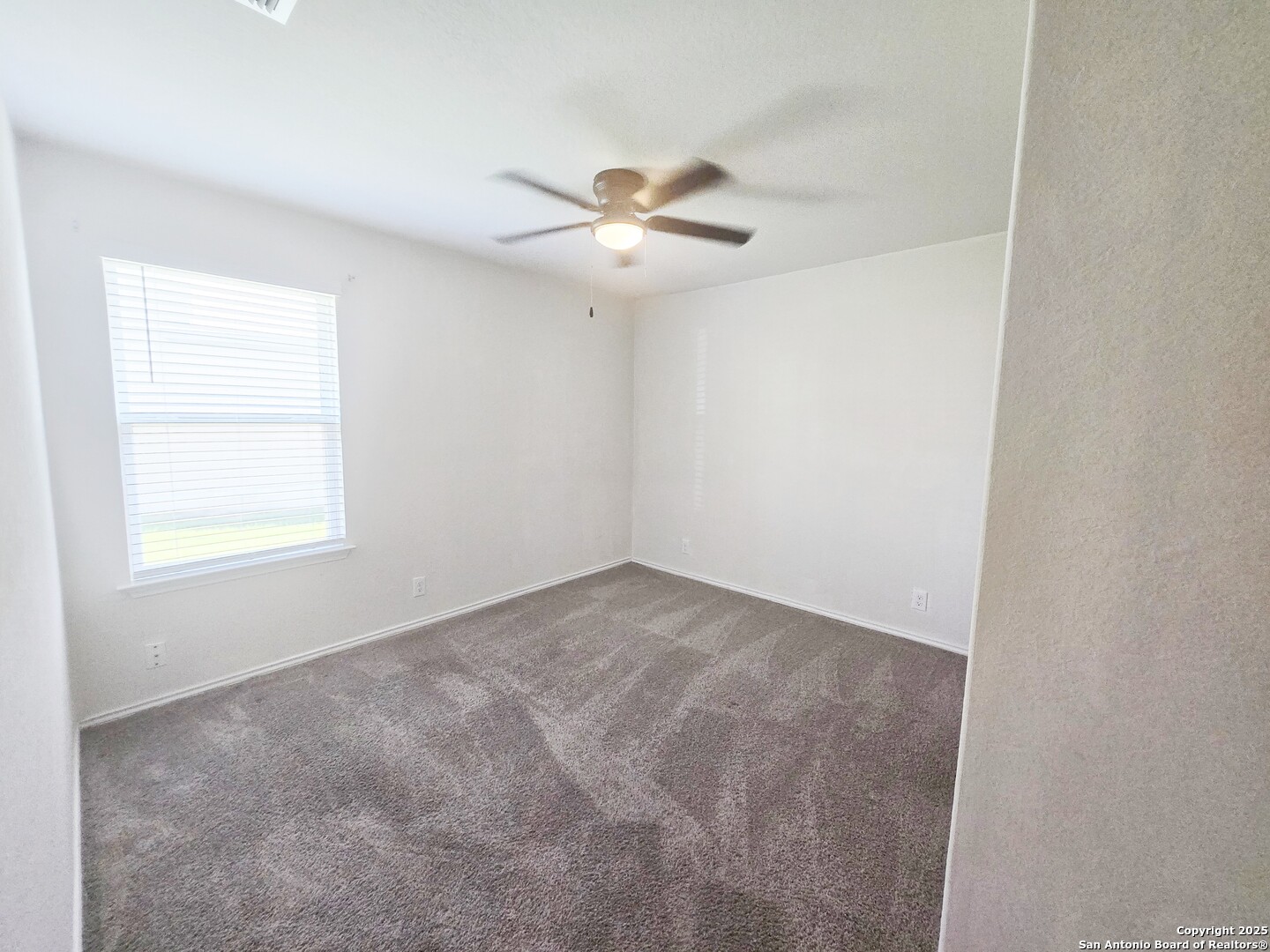 437 Middle Grn Loop Floresville, TX 78114 - Photo 19 of 25 an empty room with a window and a fan