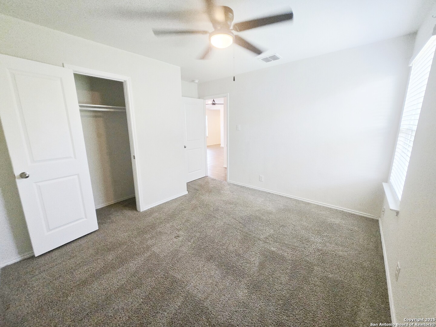 437 Middle Grn Loop Floresville, TX 78114 - Photo 20 of 25 an empty room with closet and a ceiling fan