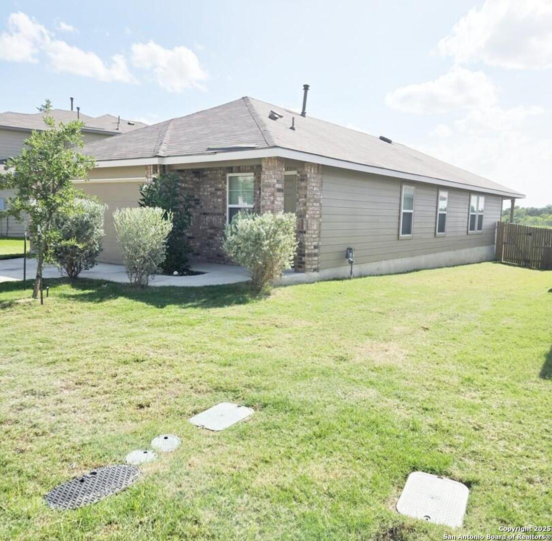 437 Middle Grn Loop Floresville, TX 78114 - Photo 2 of 25 a front view of house with yard and swimming pool