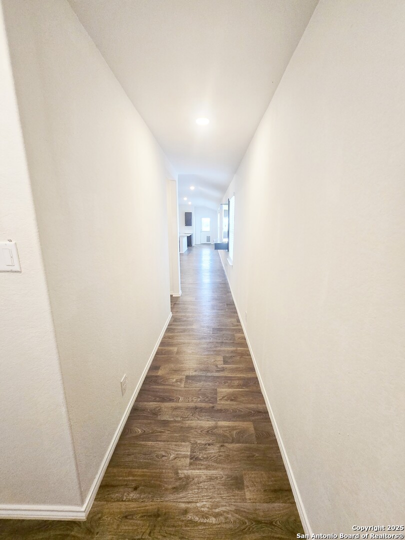 437 Middle Grn Loop Floresville, TX 78114 - Photo 8 of 25 a view of a hallway with wooden floor