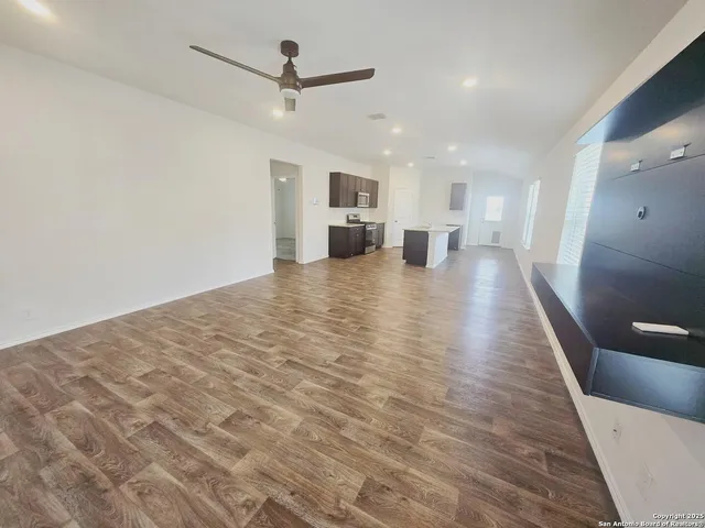 an empty room with wooden floor and white walls