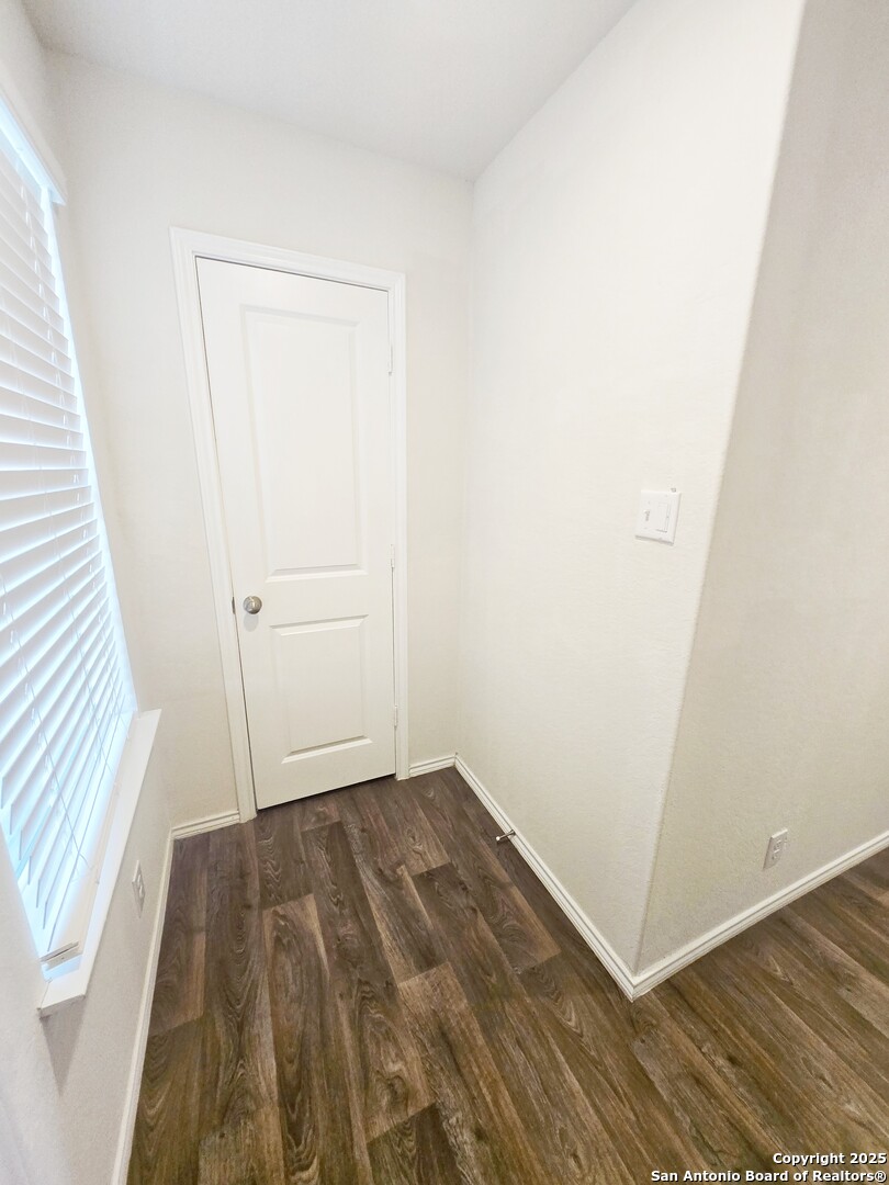 437 Middle Grn Loop Floresville, TX 78114 - Photo 10 of 25 an empty room with wooden floor and white walls