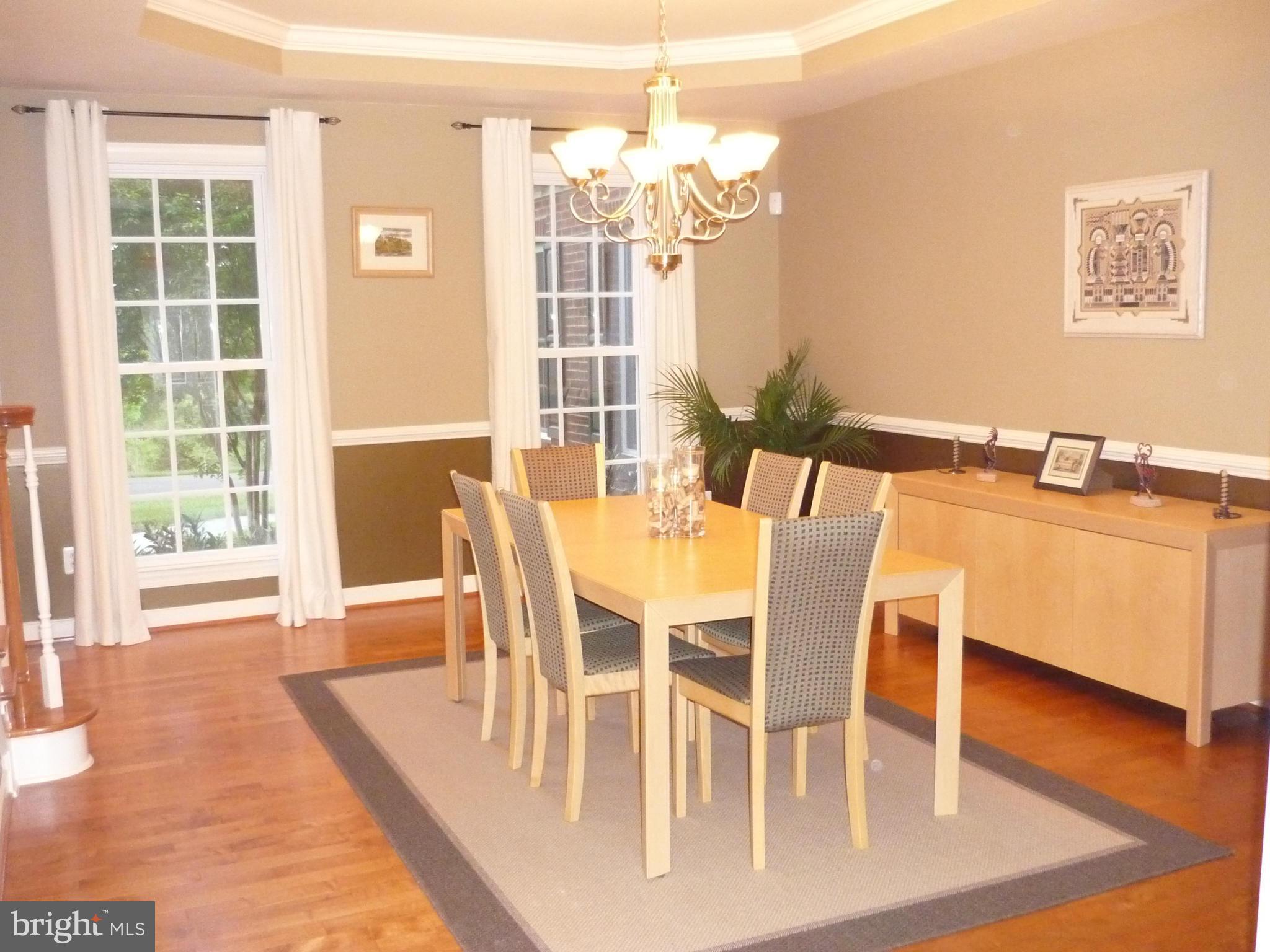7258 Joshua Tree Circle Warrenton, VA 20187 - Photo 4 of 16 a dining room with wooden floor a chandelier a glass table and chairs