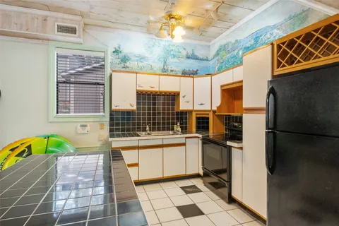 a view of a kitchen with a sink and a refrigerator