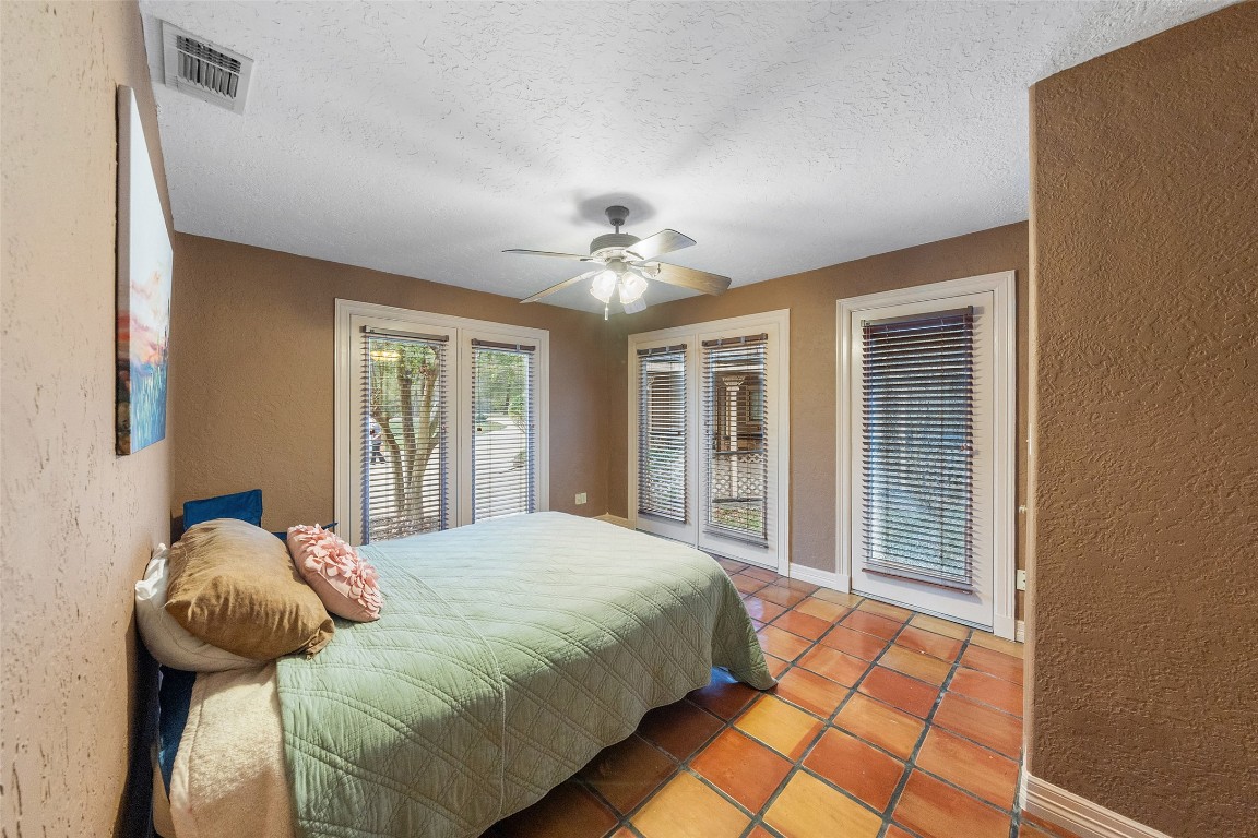 186 Lake Road Huntsville, TX 77320 - Photo 15 of 48 a bedroom with a bed and a chandelier