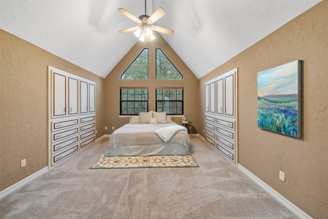 186 Lake Road Huntsville, TX 77320 - Photo 18 of 48 a spacious bedroom with a large bed and a chandelier