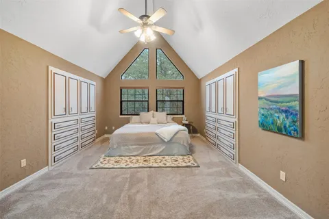 a spacious bedroom with a large bed and a chandelier