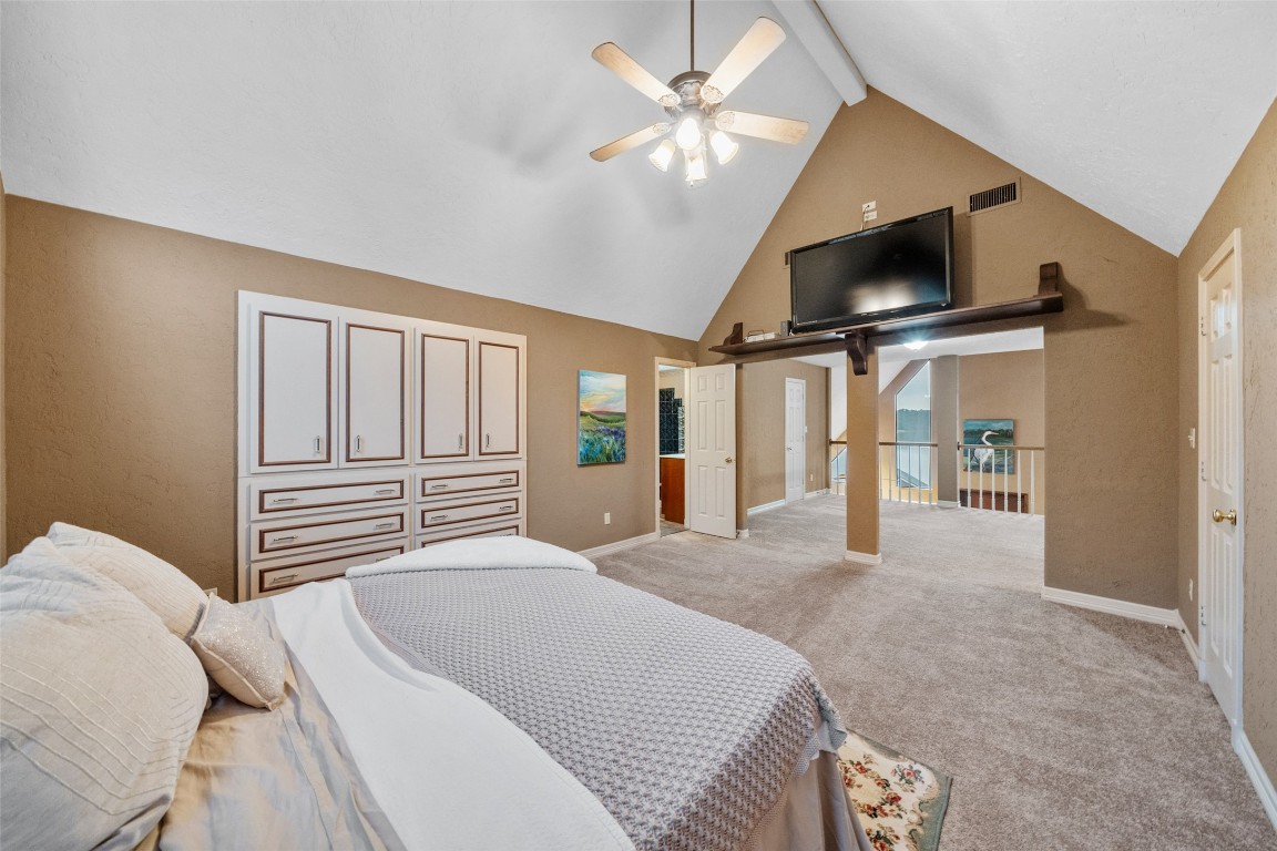 186 Lake Road Huntsville, TX 77320 - Photo 20 of 48 a bedroom with a large bed a flat screen tv and a large window with the outer view