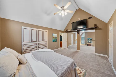 a bedroom with a large bed a flat screen tv and a large window with the outer view