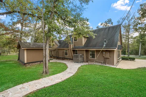 a front view of house with yard and trees in the background