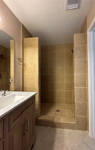 a bathroom with a shower a sink and a mirror