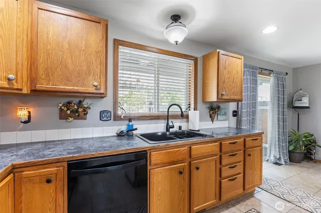 a kitchen with granite countertop a sink cabinets and window