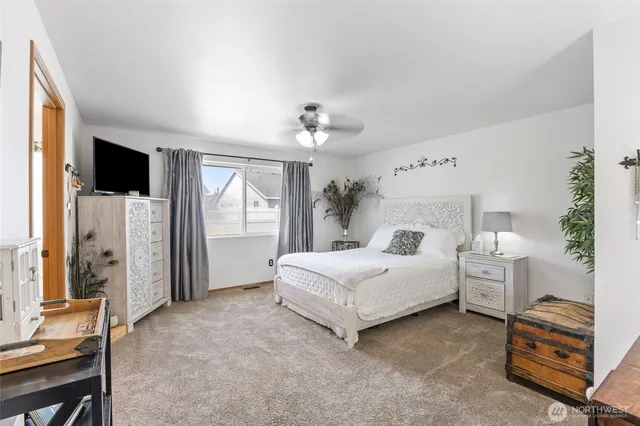 a spacious bedroom with a bed and a chair