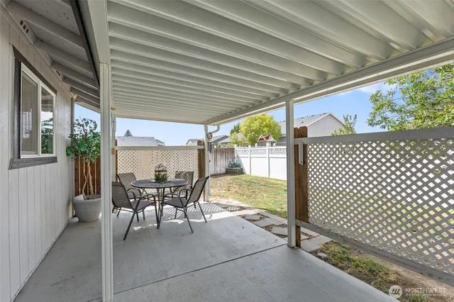 a view of a patio with a table chairs and backyard