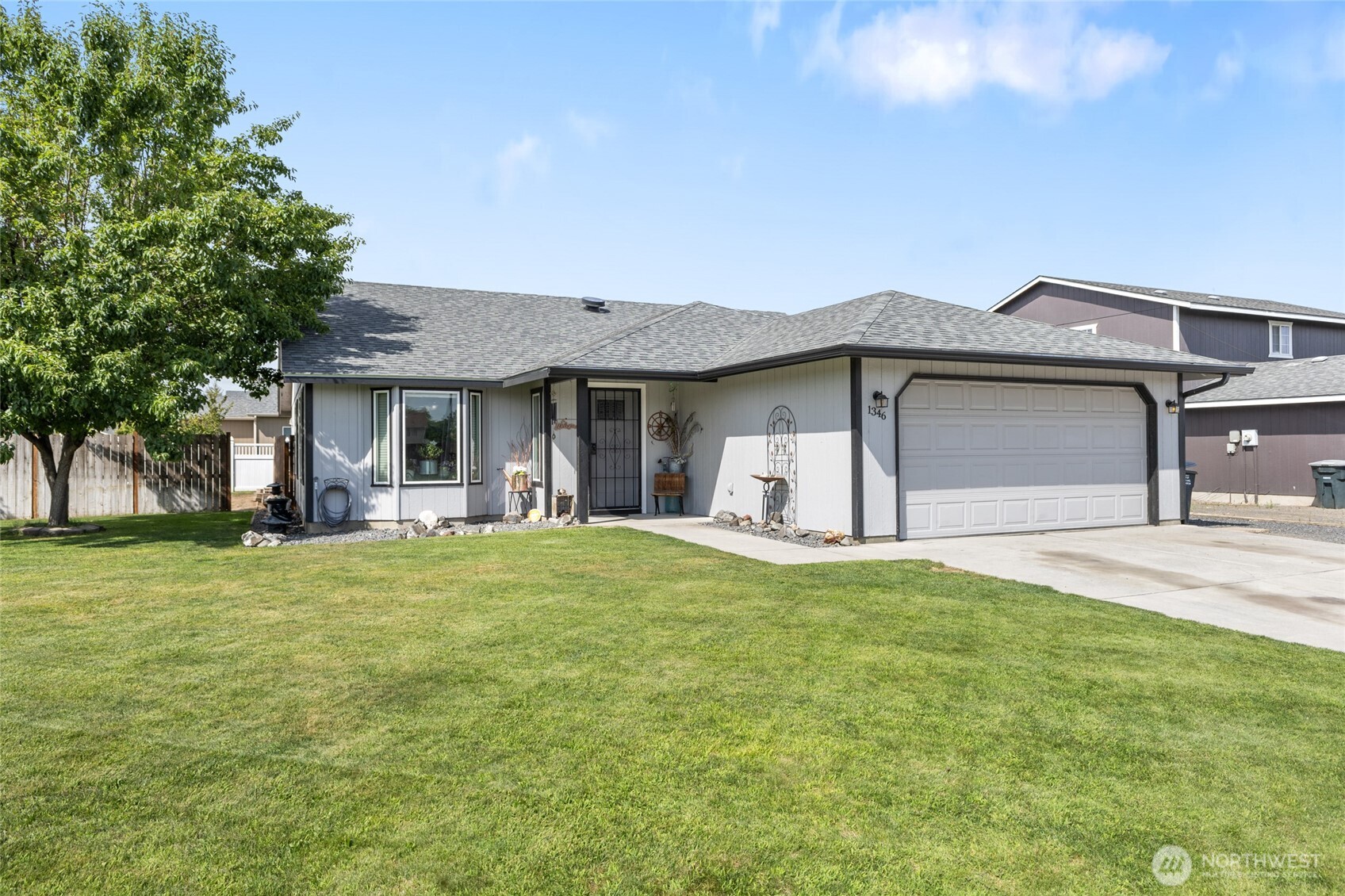 1346 Greens Loop Moses Lake, WA 98837 - Photo 3 of 39 a front view of a house with a garden and trees