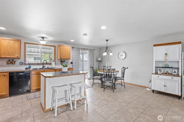 a kitchen with white cabinets and chairs