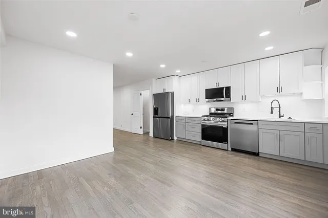 a kitchen with stove cabinets and stainless steel appliances