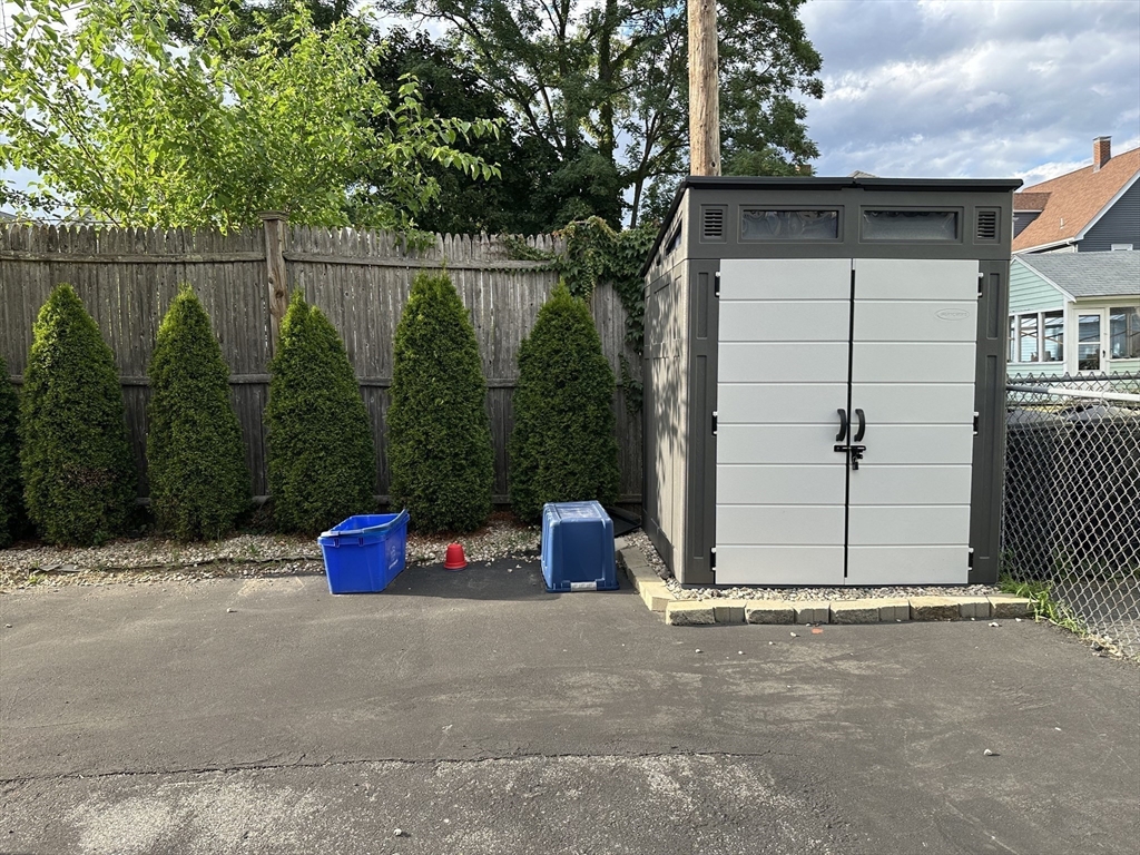 209 Adams Street, Unit B Malden, MA 02148 - Photo 28 of 30 a backyard of a house with barbeque oven and wooden fence