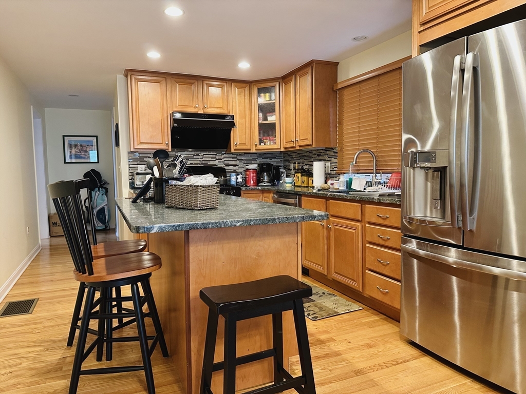 209 Adams Street, Unit B Malden, MA 02148 - Photo 3 of 30 a kitchen with stainless steel appliances granite countertop a stove top oven a sink dishwasher and wooden cabinets