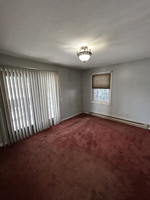 3 Hinman Street, Unit 2 Sturbridge, MA 01518 - Photo 4 of 9 an empty room with windows and chandelier fan