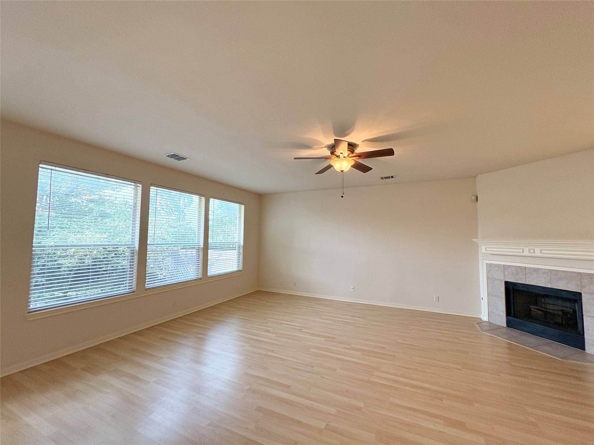 7006 Rambollet Terrace Round Rock, TX 78681 - Photo 11 of 38 A welcoming living area showcases light wood flooring and a cozy fireplace, perfect for gatherings.