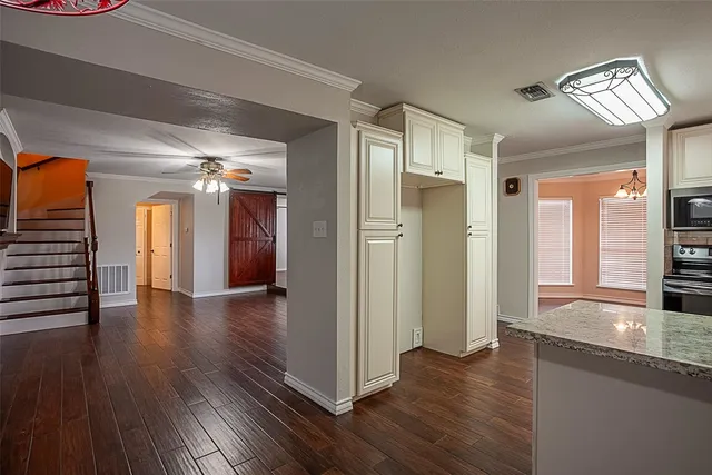 a view of a hallway with wooden floor and staircase