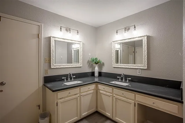 a bathroom with double sink and a mirror