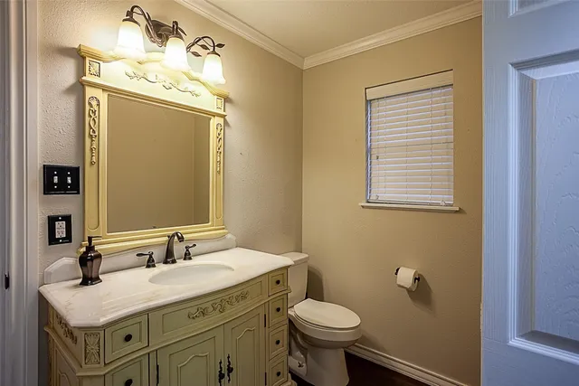 a bathroom with a granite countertop sink toilet and mirror