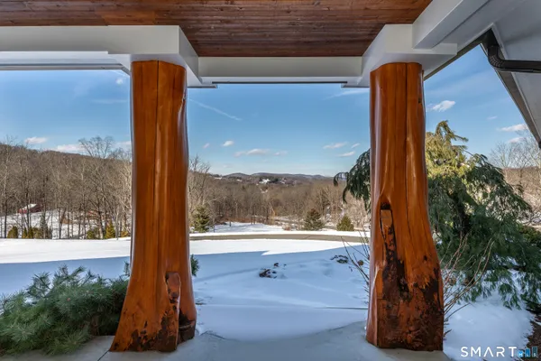 a view of a porch with a floor to ceiling window and wooden floor