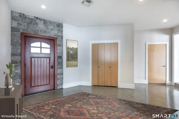 a view of a hallway with wooden floor and a bathroom