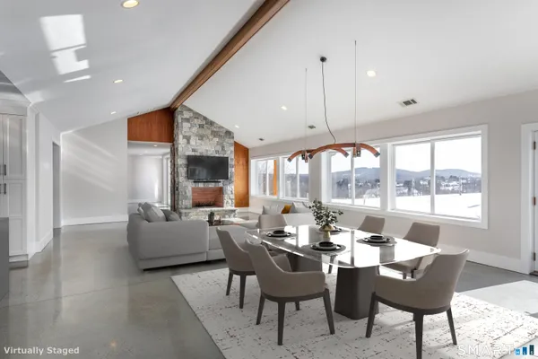 a dining room with furniture a rug and a large window