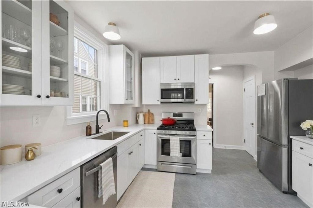 3145 Huntington Road Shaker Heights, OH 44120 - Photo 14 of 28 Modern kitchen featuring white cabinetry, stainless steel appliances, a gas range, white countertops, and contemporary light fixtures