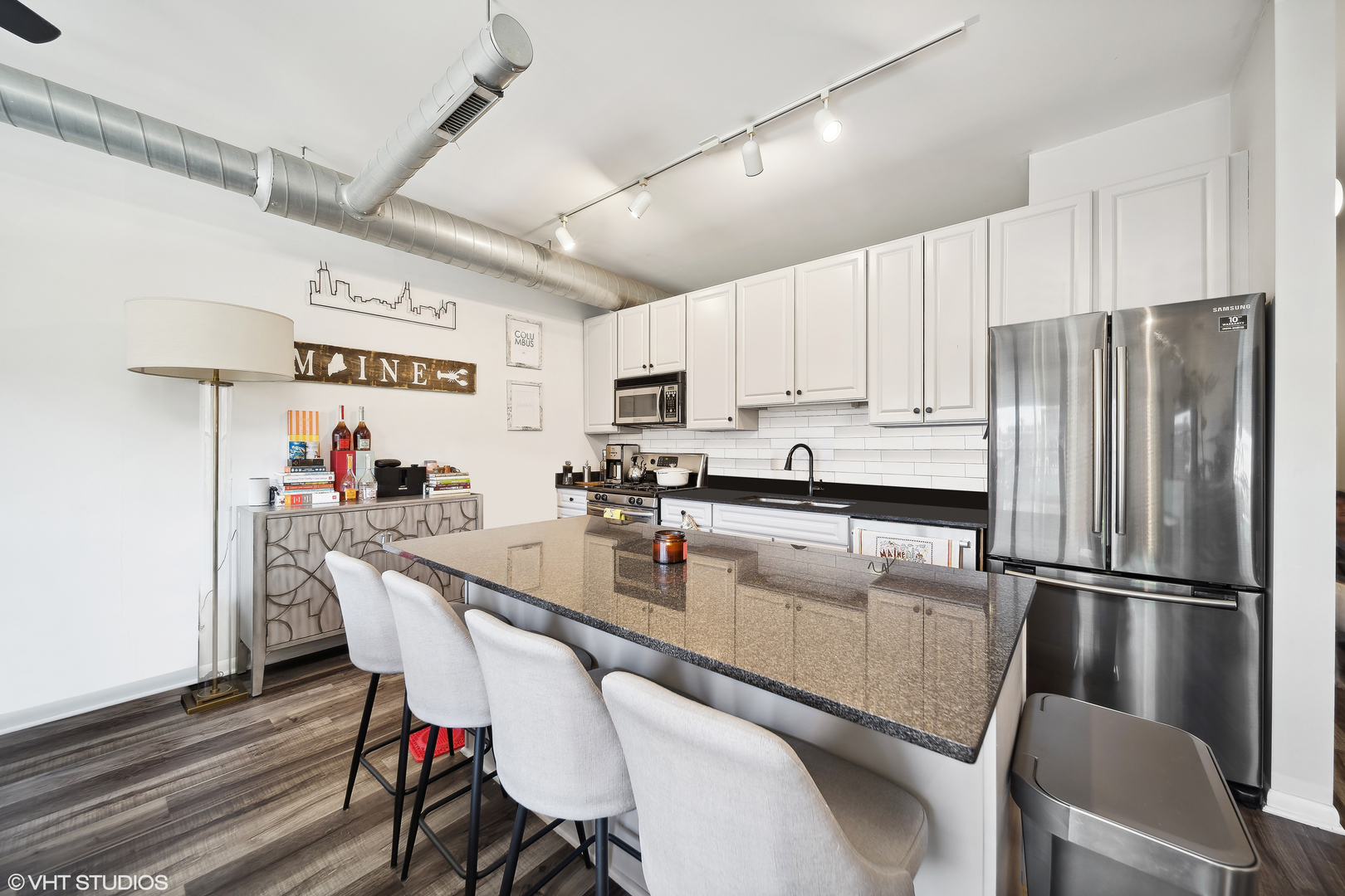 1200 West Monroe Street, Unit 418 Chicago, IL 60607 - Photo 8 of 17 a kitchen with stainless steel appliances a refrigerator a stove a sink dishwasher a dining table and chairs with wooden floor