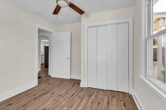 a view of empty room with wooden floor and window
