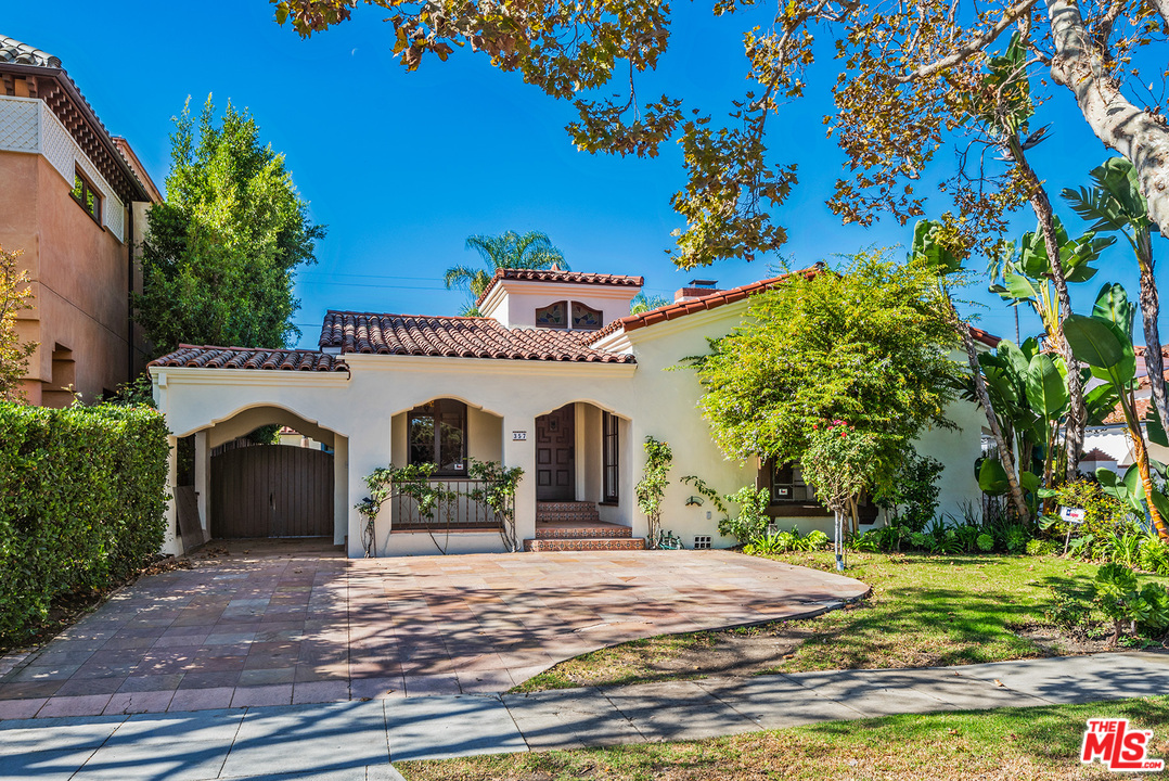 a front view of a house with a garden
