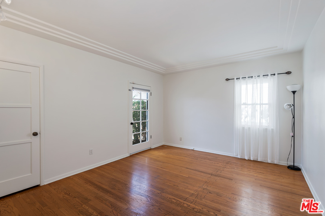 357 South La Peer Drive Beverly Hills, CA 90211 - Photo 18 of 31 an empty room with wooden floor and windows