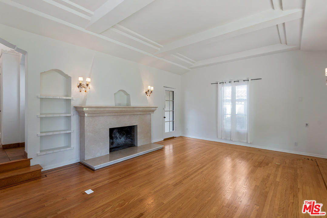 357 South La Peer Drive Beverly Hills, CA 90211 - Photo 6 of 31 a view of empty room with wooden floor and fireplace