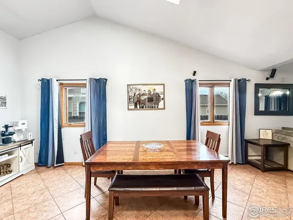 a living room with a table chairs and kitchen view