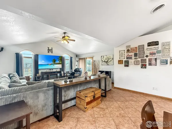 a living room with furniture kitchen view and a large window