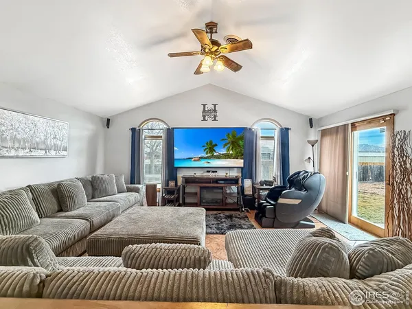 a living room with furniture a chandelier and a large window