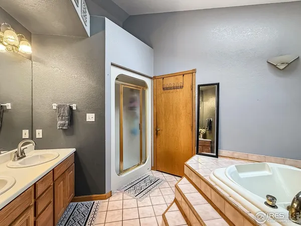 a bathroom with a tub sink and mirror