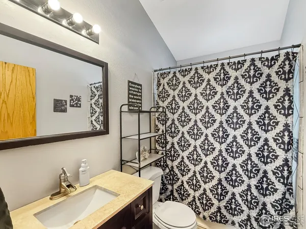 a bathroom with a sink mirror vanity and toilet